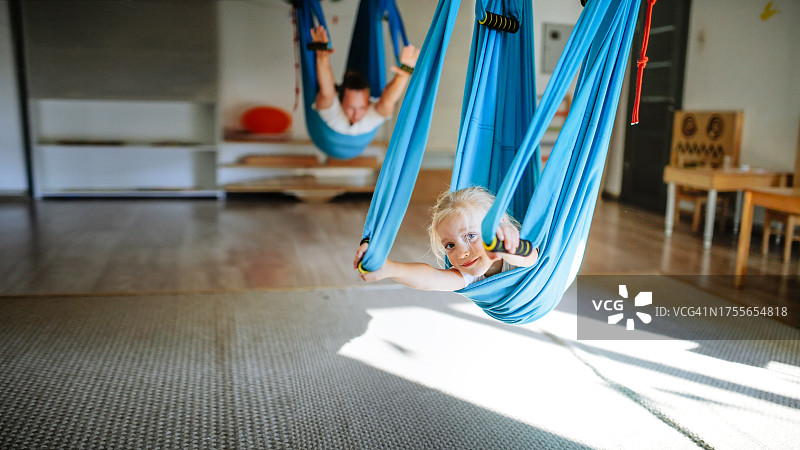 空中瑜伽：儿童与母亲在蓝色吊床中，banner图片素材