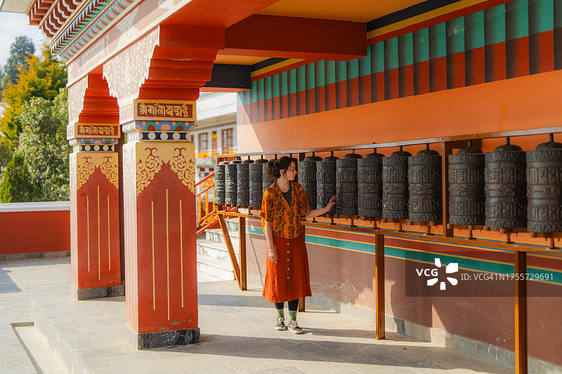 在藏族寺院中使用转经筒的妇女图片素材