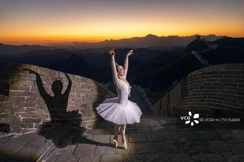 中国女人芭蕾舞者身穿白色连衣裙在长城蓝色时刻跳舞，中国北京河北金山岭图片素材