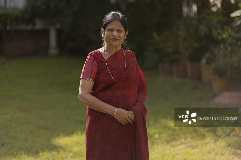 年长的女人站在后院的肖像图片素材
