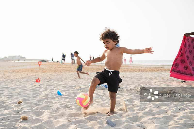 儿童在沙滩上玩球图片素材