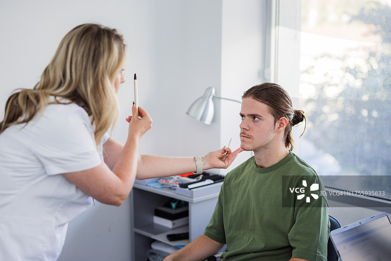 眼科检查中跟随笔的年轻男子图片素材