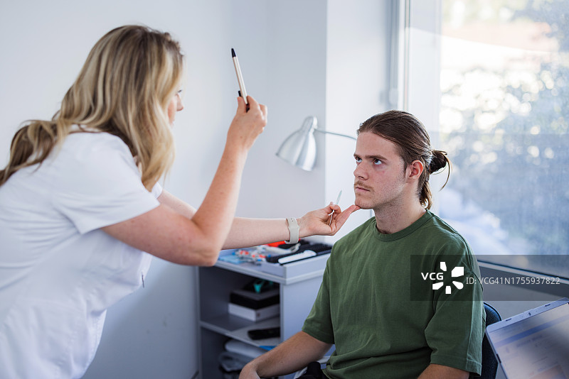 眼科检查中跟随笔的年轻男子图片素材