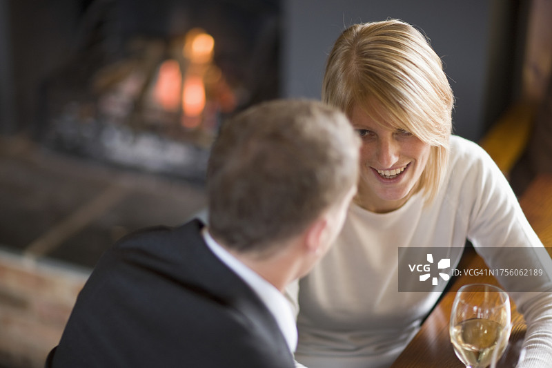 情侣坐在壁炉旁喝葡萄酒图片素材