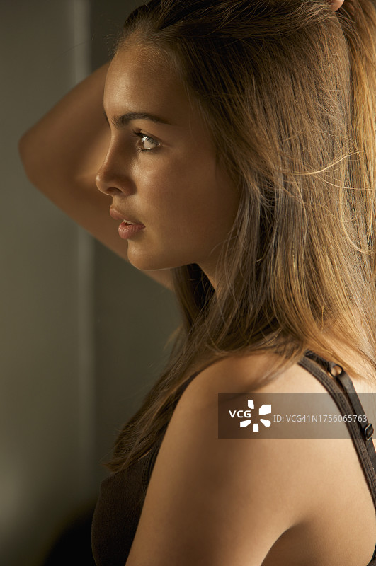 向后拉头发的年轻女性侧面照图片素材