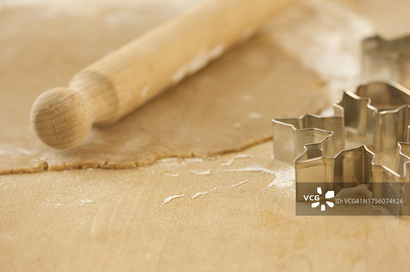 擀开的糕点面团与木制擀面杖和饼干模具特写图片素材