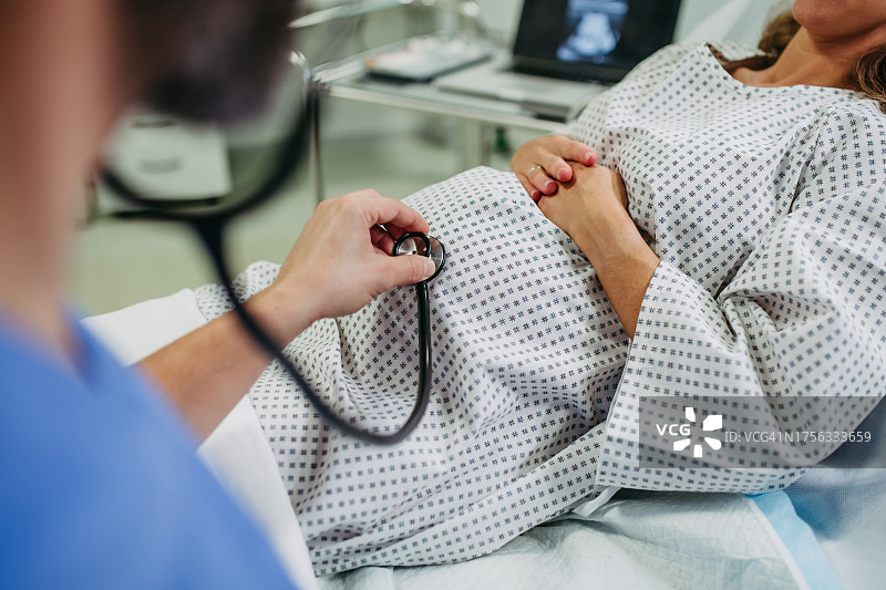 医生用听诊器听胎儿的心跳，妇科医生检查孕妇，了解婴儿在怀孕期间的健康状况，无创方法图片素材