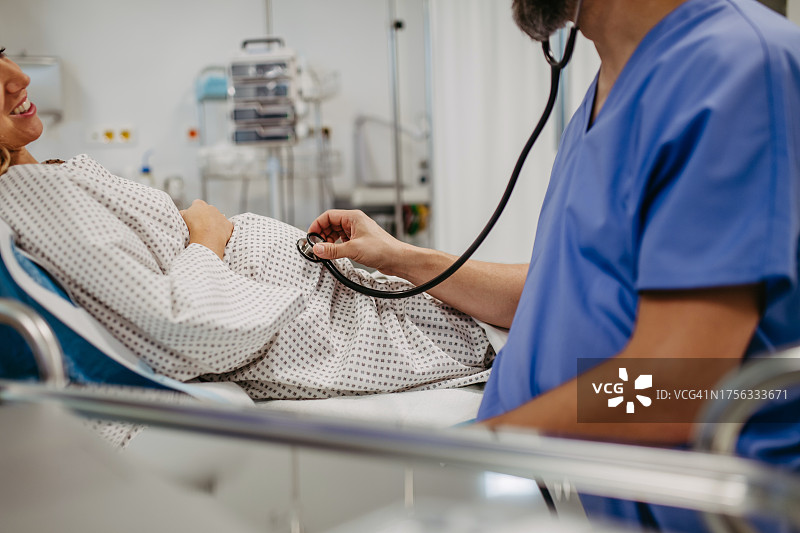 医生用听诊器听胎儿的心跳，妇科医生检查孕妇，了解婴儿在怀孕期间的健康状况，无创方法图片素材