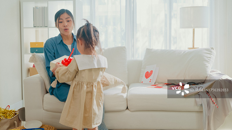 亚洲家庭女儿在母亲节为妈妈送贺卡和礼物图片素材