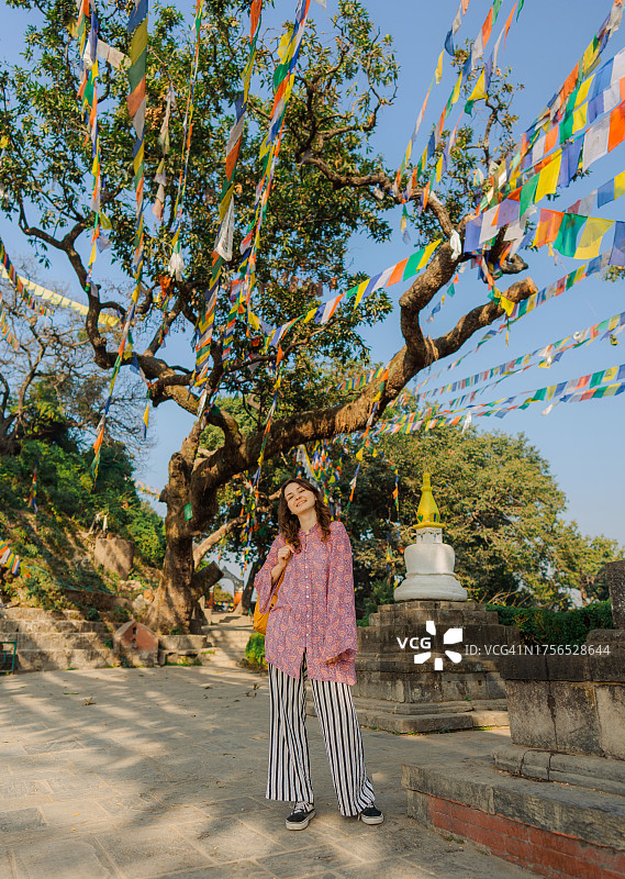 站在藏族祈祷旗下的女人图片素材