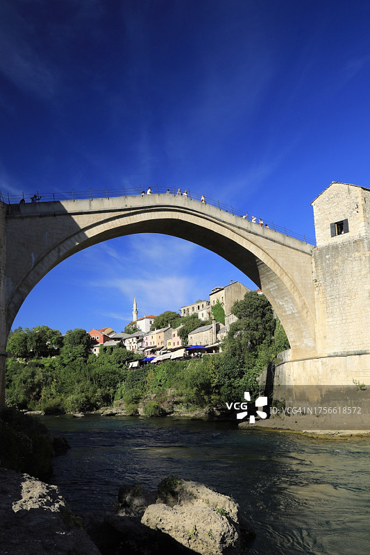 游客走过莫斯塔尔历史悠久的人行桥图片素材