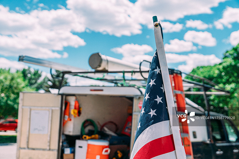 美国蓝领工作：美国国旗和带建筑或公共事业工具的卡车图片素材