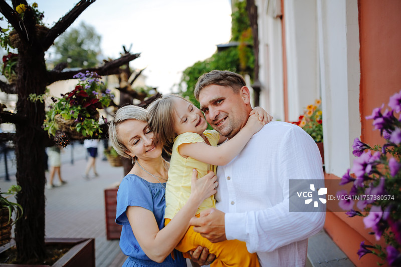 温馨时刻：父母与患有唐氏综合征的孩子在城市漫步图片素材