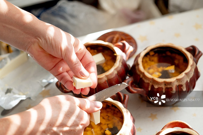 窗边白色桌子上罐中的炖土豆和南瓜图片素材