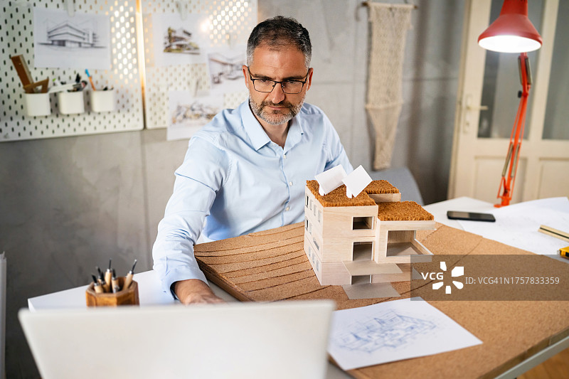 白人男建筑师在视频通话中向客户展示他制作的建筑模型图片素材