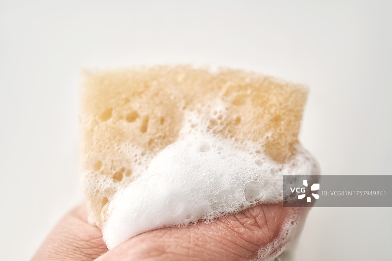 手指挤压海绵使其产生泡沫图片素材