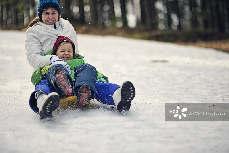母子享受冬季雪橇之旅图片素材