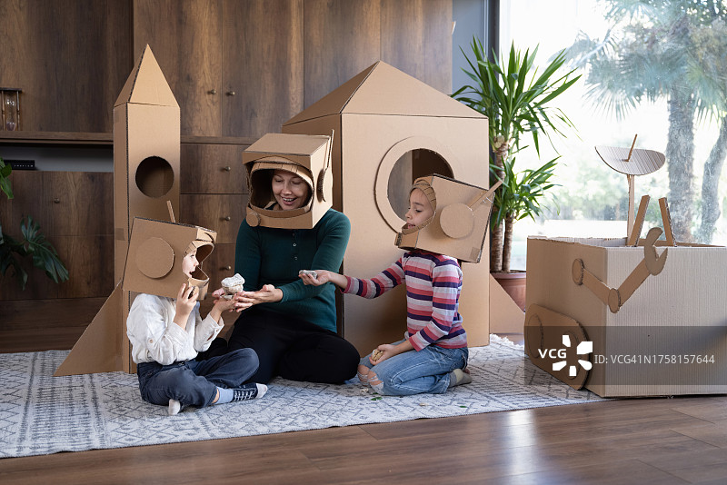 母亲、儿子和女儿玩宇航员角色扮演游戏的家庭图片素材