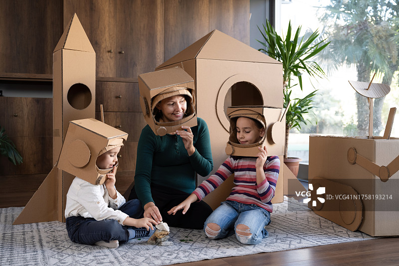 母亲、儿子和女儿玩宇航员角色扮演游戏的家庭图片素材