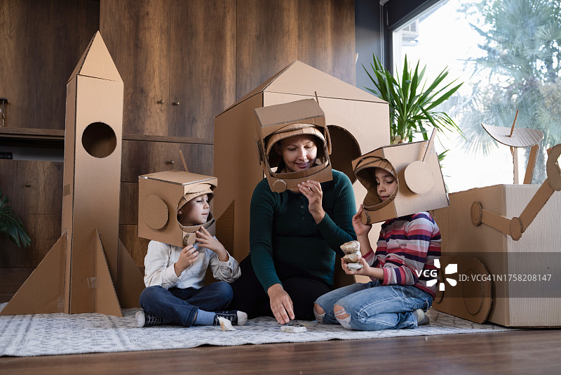 母亲、儿子和女儿玩宇航员角色扮演游戏的家庭图片素材