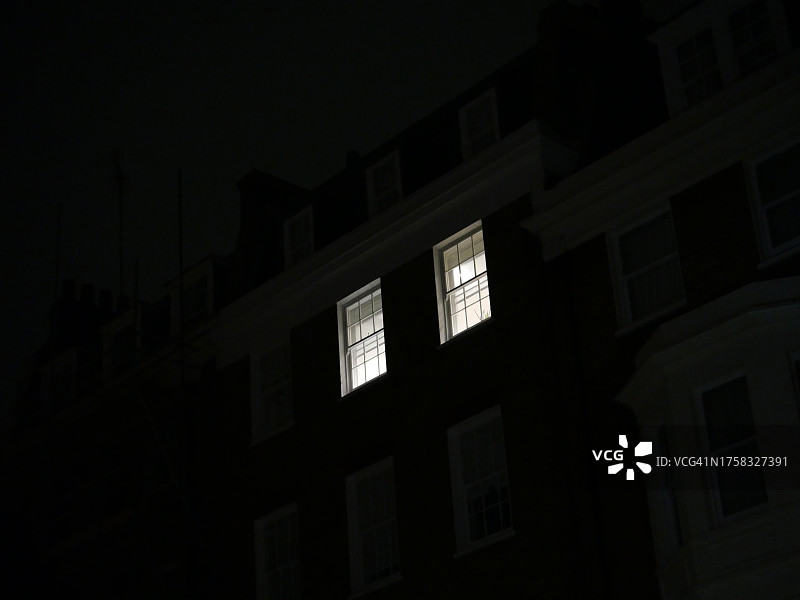 英国伦敦夜晚公寓的两扇亮灯窗户图片素材