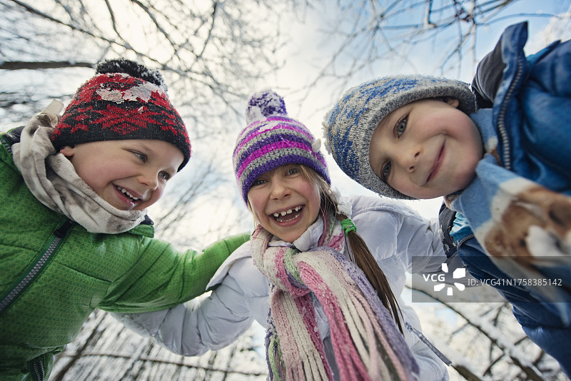 在森林里享受冬天的三个可爱孩子图片素材