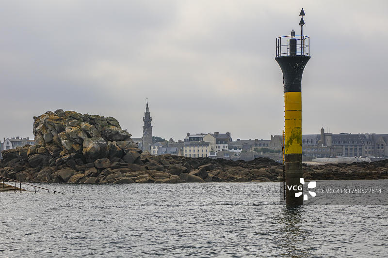 在英吉利海峡的Île de Batz岛和罗斯科夫之间的海上岩石,后方是罗斯科夫教堂,法国图片素材