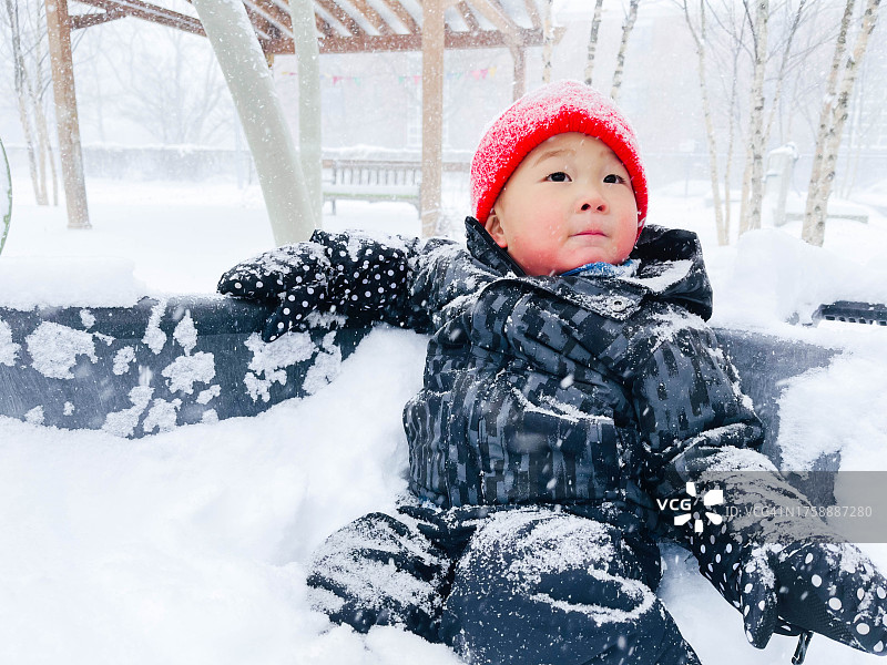 可爱的小男孩在雪中操场玩耍图片素材