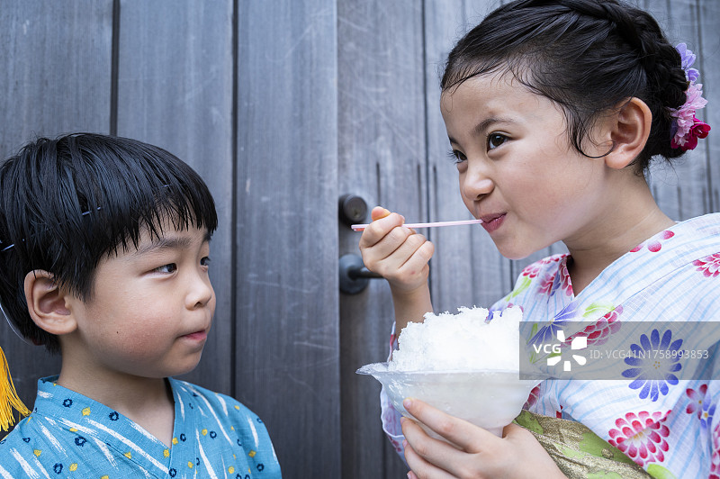 穿着浴衣在祭典小吃摊玩耍的儿童图片素材