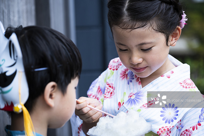 穿着浴衣在祭典小吃摊玩耍的儿童图片素材