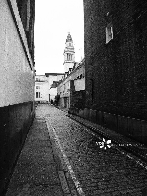 伦敦马里波恩区两栋房屋之间狭窄的鹅卵石街道侧视图图片素材