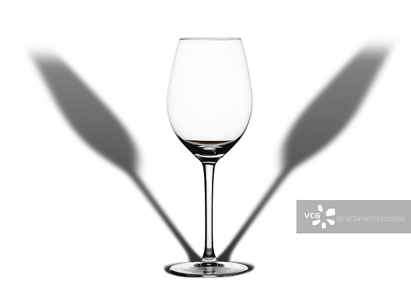 白色背景上的葡萄酒杯和长影图片素材