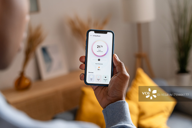 非洲裔美国男子手持带有温度应用程序的智能手机屏幕的局部照片图片素材