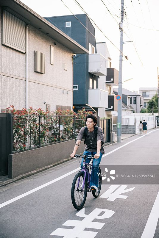 年轻男人在城市里骑自行车图片素材