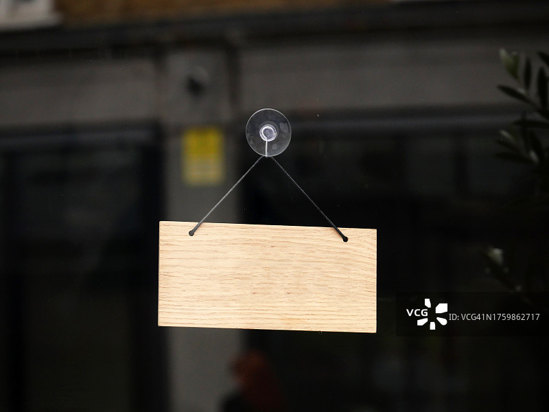 挂在英国伦敦商店前门窗户上的小型空矩形木制标牌图片素材