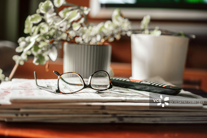 床头柜报纸上的阅读眼镜图片素材