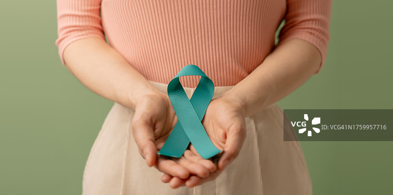 手持绿色丝带的女子（泰国），背景为绿色图片素材