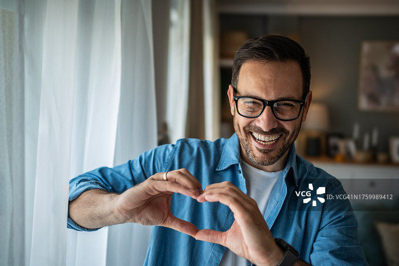 快乐的白人男子用手比心图片素材