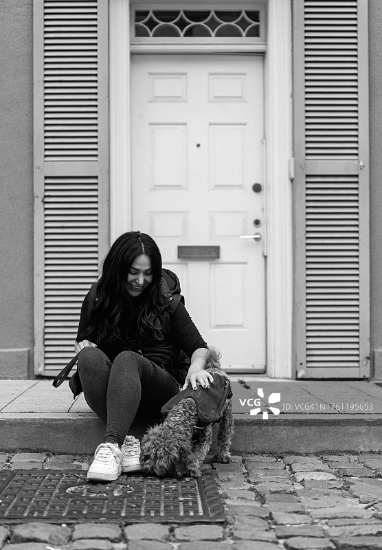 年轻女子和她的玩具贵宾犬在纽约曼哈顿街头图片素材