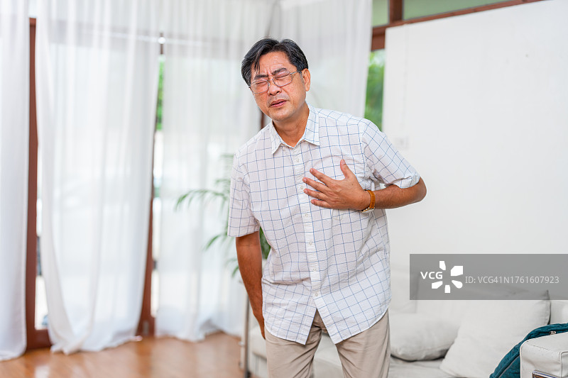 一位年长的市民在家中感到胸痛图片素材