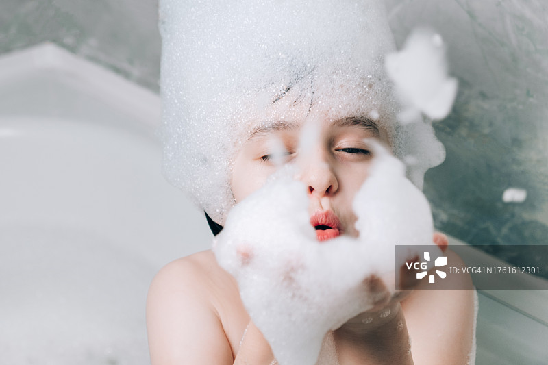 小女孩在浴缸里玩泡沫图片素材