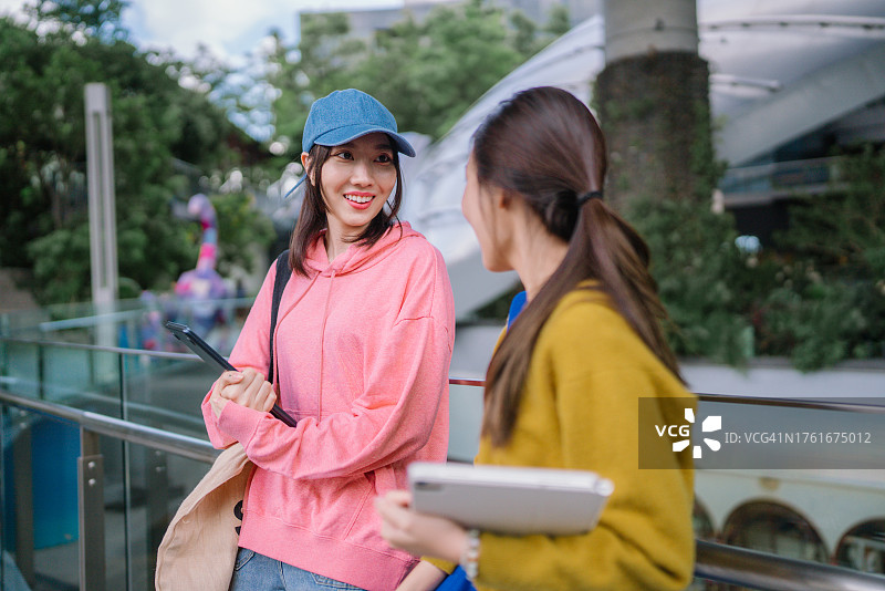 一群亚洲学生在课前走在大学里交谈图片素材