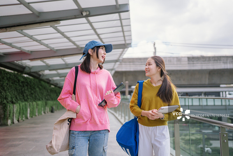 一群亚洲学生在课前走在大学里交谈图片素材