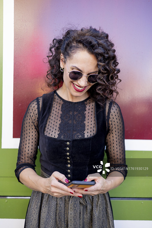 身穿巴伐利亚传统服装的使用智能手机的女人图片素材