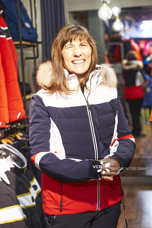 女子在服装店试穿外套，对着镜头微笑图片素材