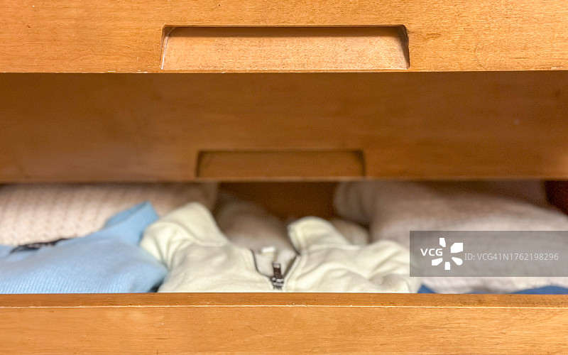 打开的梳妆台抽屉，展示整齐叠放的衣服图片素材