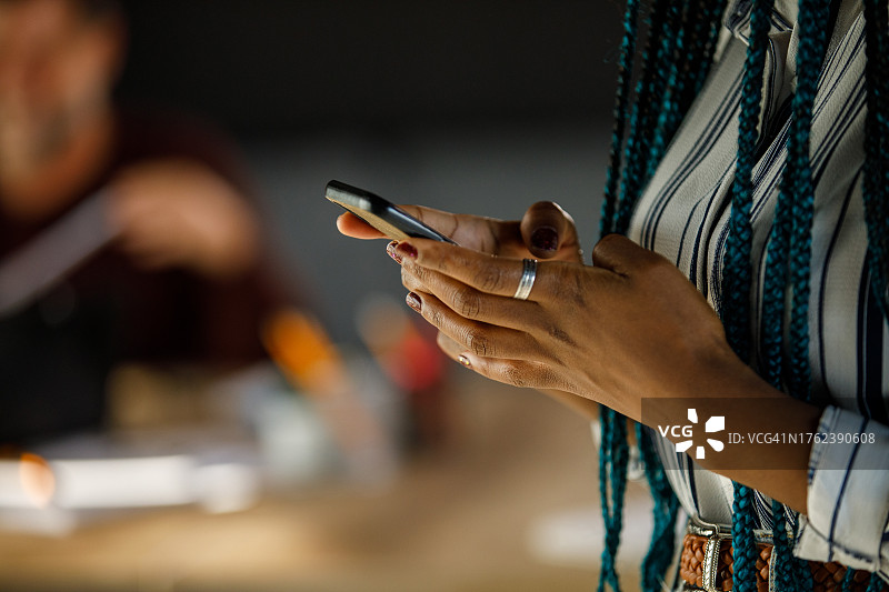 年轻女商人站在现代化的办公场所里打电话图片素材