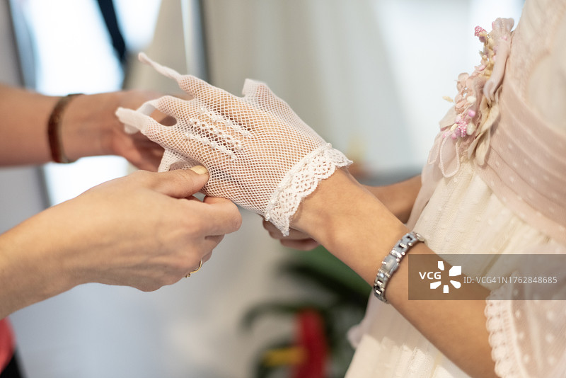 母亲为参加圣餐的女儿穿衣打扮图片素材