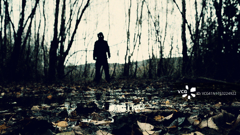 在阴森森林中，一个眼睛发光的超自然恐怖形象图片素材