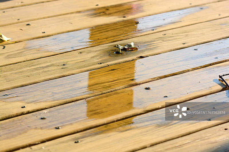 新刷漆的旧甲板上的积水图片素材